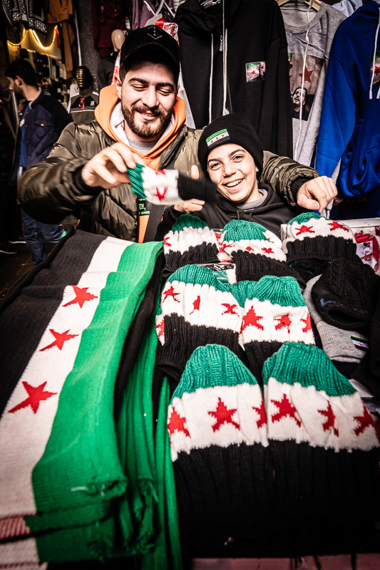 Street-Fotoreise Damaskus: Damaskus, im Suq al-Hamidiyeh. Überall werden Schals, Mützen oder Anstecker in den neuen Farben der syrischen Flagge verkauft.