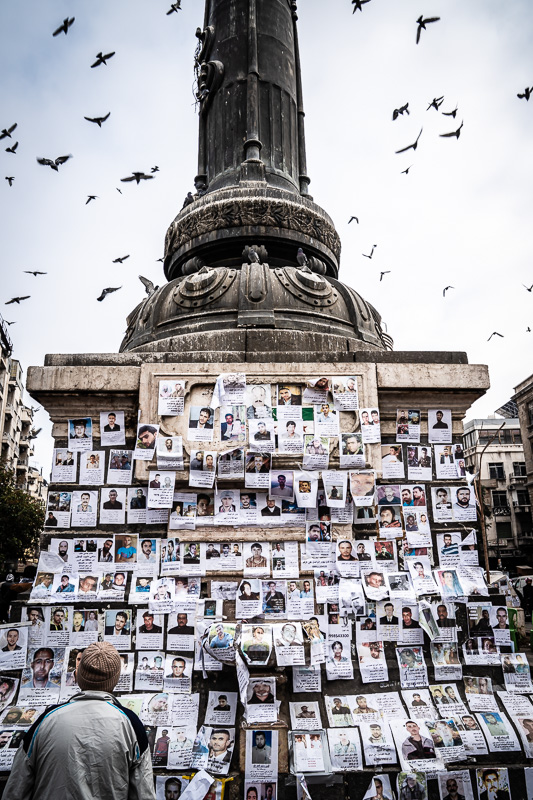 Street-Fotoreise Damaskus: Marjeh Platz (auch: Merjeh Platz; Märtyrer Platz) im Zentrum der Stadt. Während der osmanischen Herrschaft Ende des 19. Jahrhunderts entstanden, aus dieser Zeit stammt auch das "Telegrafendenkmal". An das Denkmal haben im Dezember 2024, wenige Tage nach dem Sturz des Regimes, Menschen Hunderte Zettel mit Fotos und biografischen Angaben von Vermissten aufgehängt.