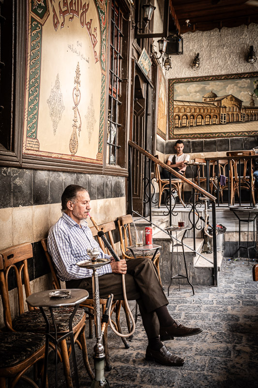 Street-Fotoreise Damaskus: Mann raucht eine Shisha im berühmten Café Noufara in der Altstadt.